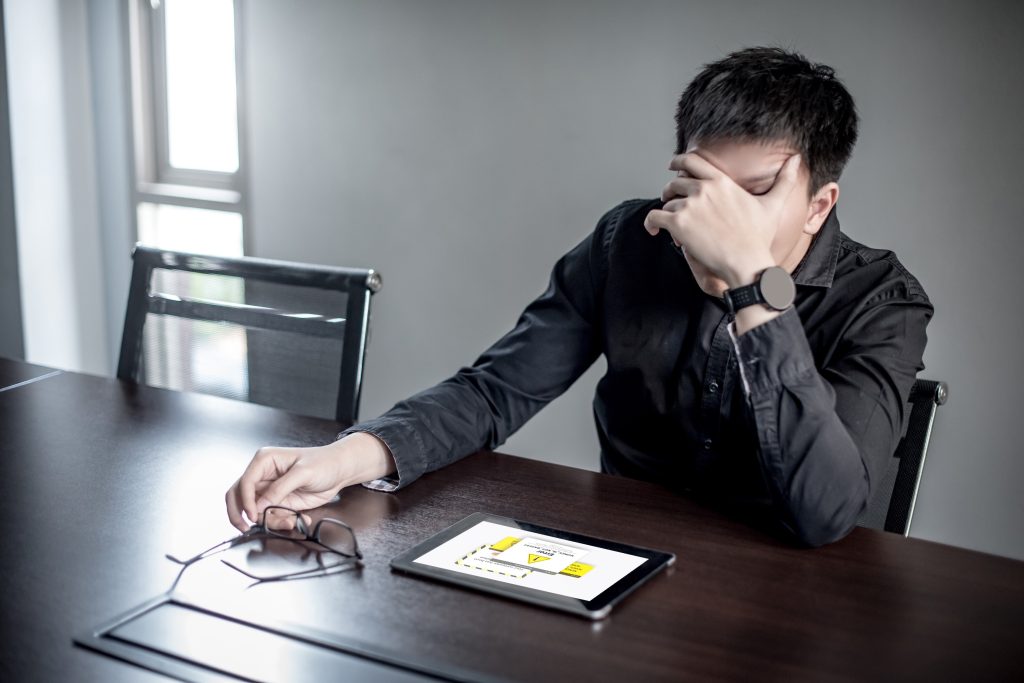 Man frustrated with all the errors received while using an app on a tablet. Bad experiences will prevent people from using an innovative product.