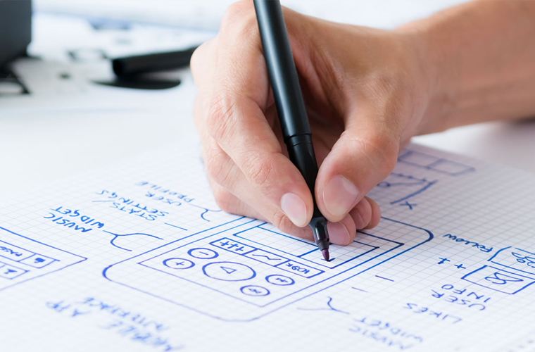 A designer drawing wireflows. Wireflows help with better visualization of a user's interaction with an application.