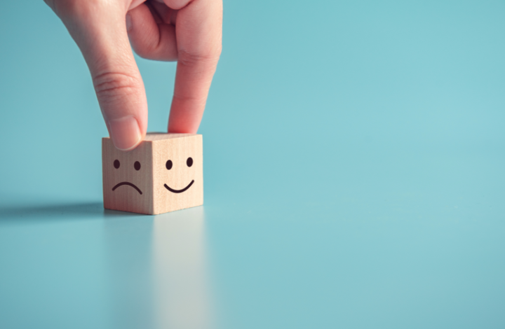 A block showing 2 faces: one is sad, the other is happy, signifying how an experience can lead to different outcomes.