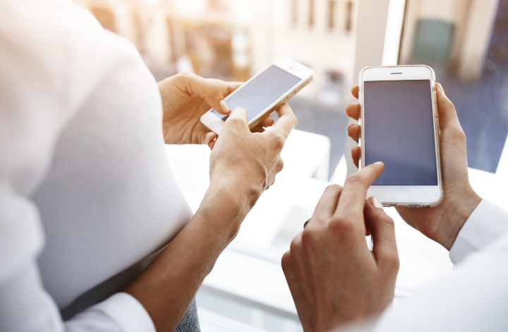 Two people using applications on their phones - If it has users, the experience should be designed.